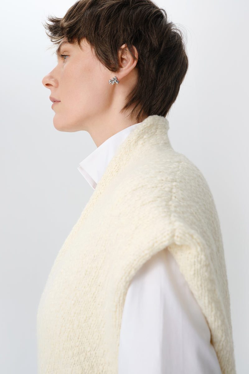 Close-up of a textured knit cardigan vest by DELEGAN, featuring detailed knitting and a cozy, stylish design.