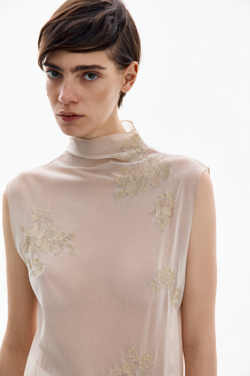 Close-up of the DELEGAN Brass Bloom midi dress showcasing intricate fabric details and elegant design elements.