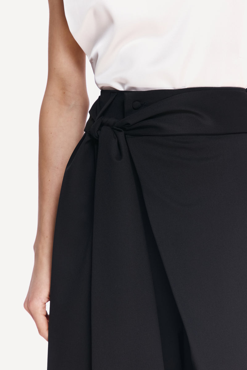 Close-up of DELEGAN BAKHROMA pants showing fabric texture and detailed stitching.