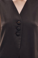 Close-up of a Petal Brown vest by DELEGAN showing textured fabric and detailed stitching.