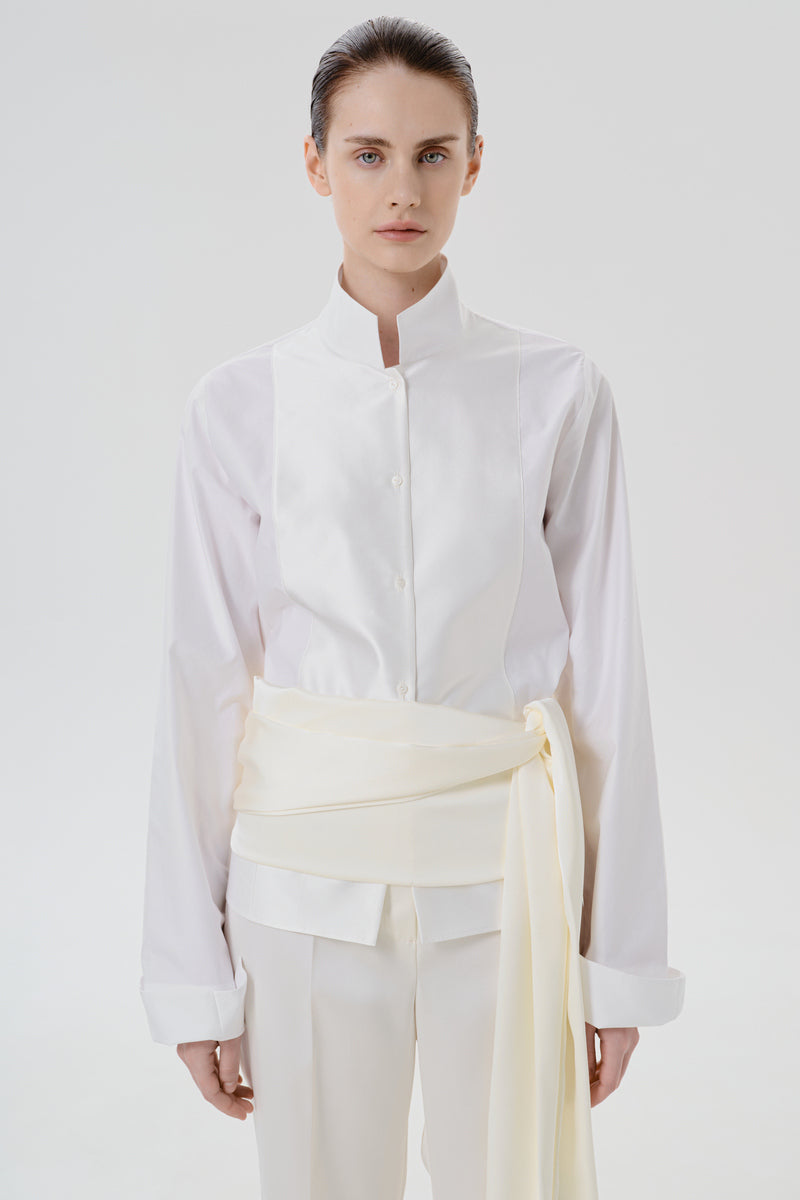 Ivory satin pants with belt by Delegan, close-up detail showing smooth fabric and stylish waist belt.