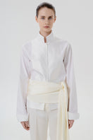 Ivory satin pants with belt by Delegan, close-up detail showing smooth fabric and stylish waist belt.