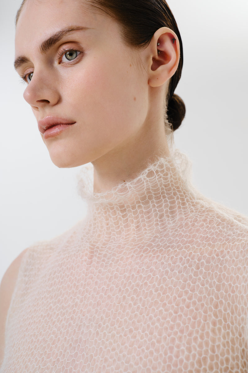 Close-up of a DELEGAN soft skin sheer knit top, showing the delicate fabric and fine texture of the women's top.