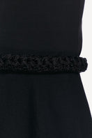 Close-up of a black midi skirt from DELEGAN, showing the fabric texture and detailed stitching for a stylish, modern look.