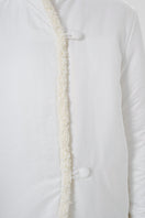 Close-up of a white DELEGAN jacket showing fabric texture and detailed stitching on the jacket's front.