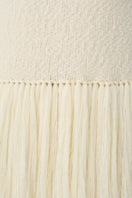 Close-up of a textured knit DELEGAN cardigan vest featuring detailed woven patterns and soft fabric.