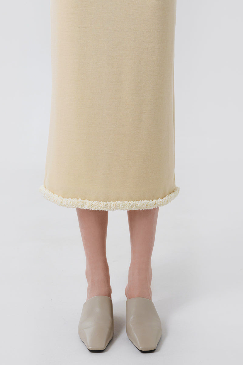 Close-up of a DELEGAN wool midi skirt showing soft, textured fabric and elegant stitching details.