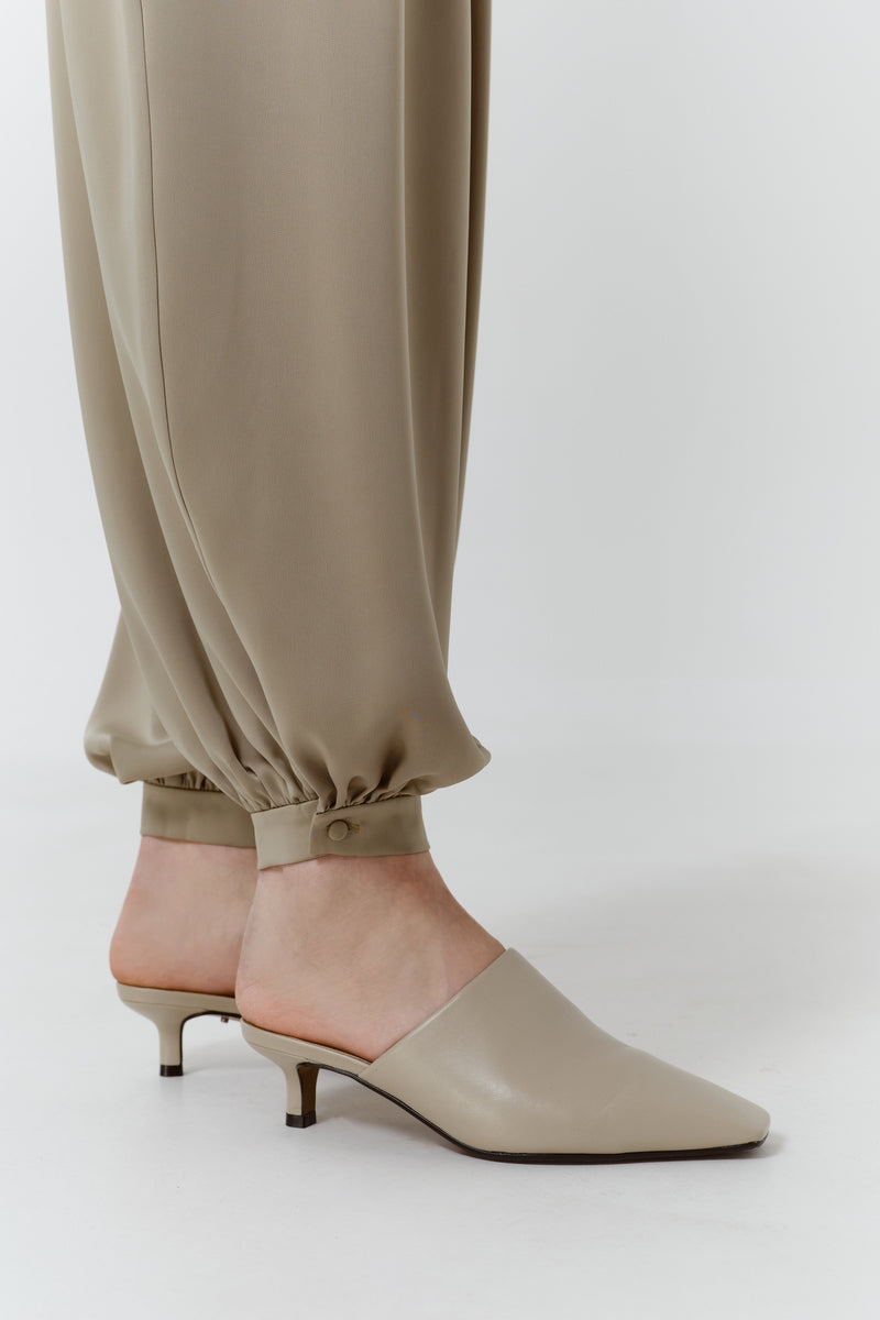 Close-up of DELEGAN Olive Flow Pants showing the fabric texture and detailed stitching on stylish olive green pants.
