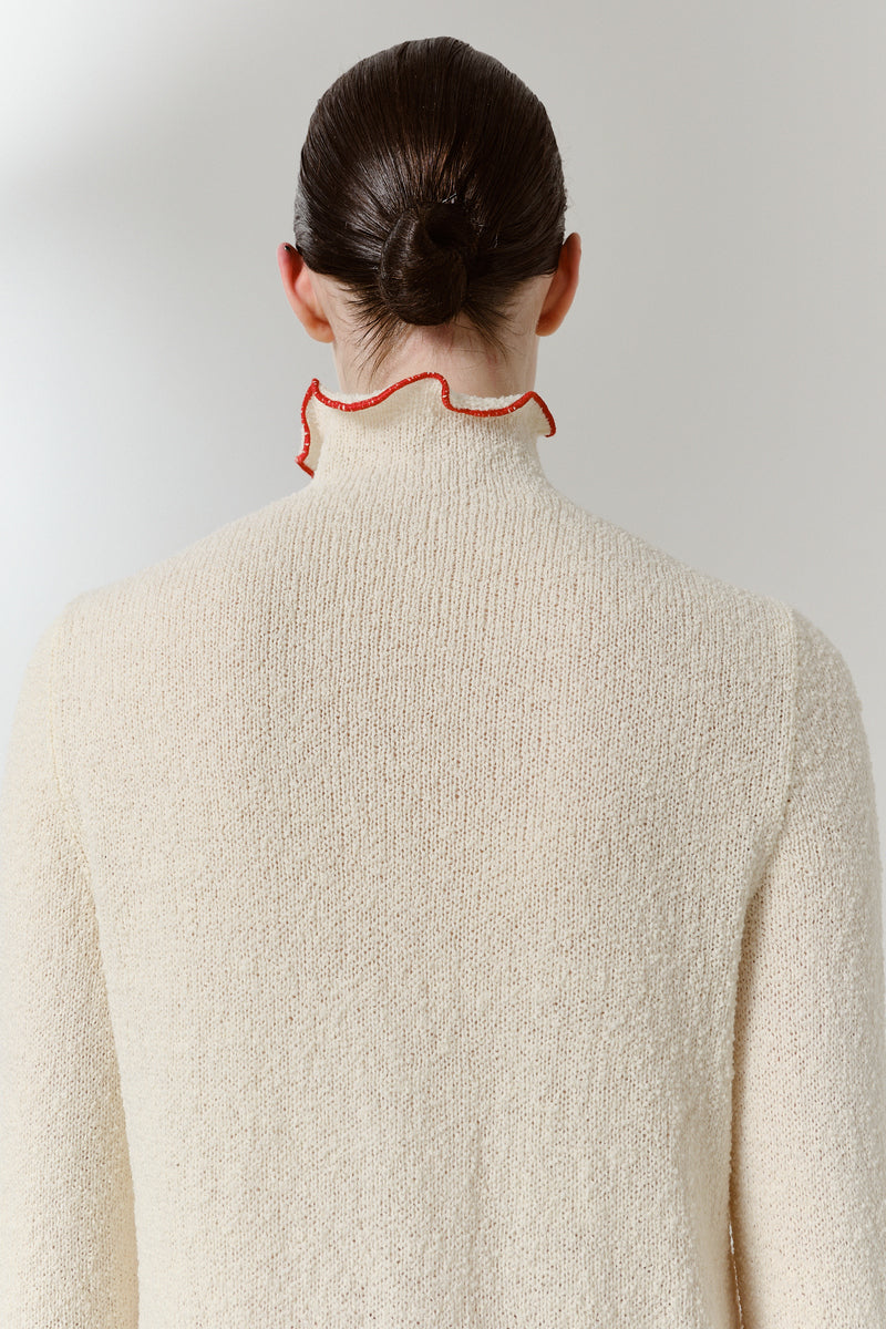 Close-up of a red blush midi dress by DELEGAN, showing the back detail and elegant fabric texture.