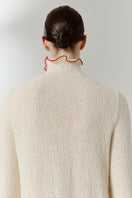 Close-up of a red blush midi dress by DELEGAN, showing the back detail and elegant fabric texture.