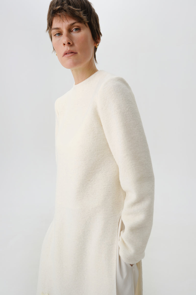 Close-up of the DELEGAN statement wool midi dress showing textured fabric and stylish side detail.
