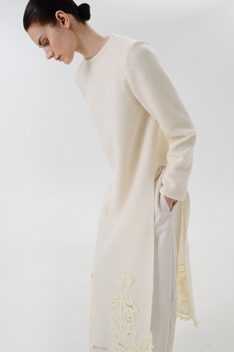 Close-up of a DELEGAN statement wool midi dress showing textured fabric and elegant design details.