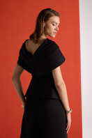Close-up of Joanna Andraos black crepe two-piece co-ord set with draped cape, showcasing elegant fabric and stylish design.