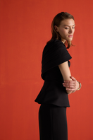 Joanna Andraos black crepe two-piece co-ord set with draped cape, close-up showing fabric texture and elegant design details.