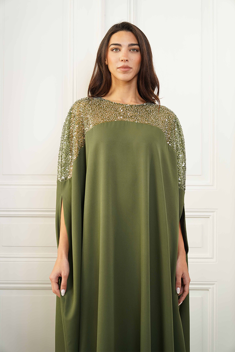 Close-up of Joanna Andraos embroidered olive green gown showcasing detailed floral embroidery and luxurious fabric.