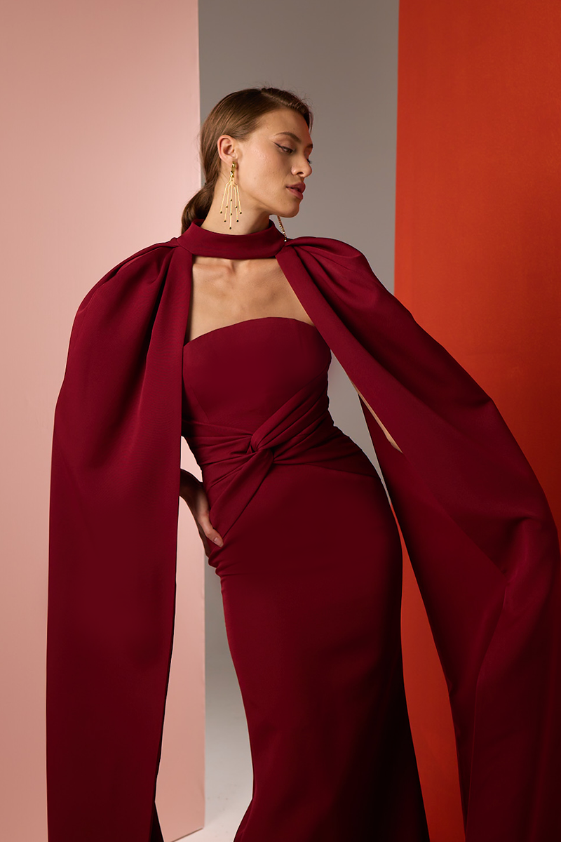 Close-up of a Burgundy Twist Gown by Joanna Andraos, showcasing elegant fabric and intricate twisted design detail.