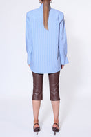 Light blue IRMA blouse by AGGI by HALEWSKI, stylish shirt with a relaxed fit and soft fabric, displayed on a hanger.