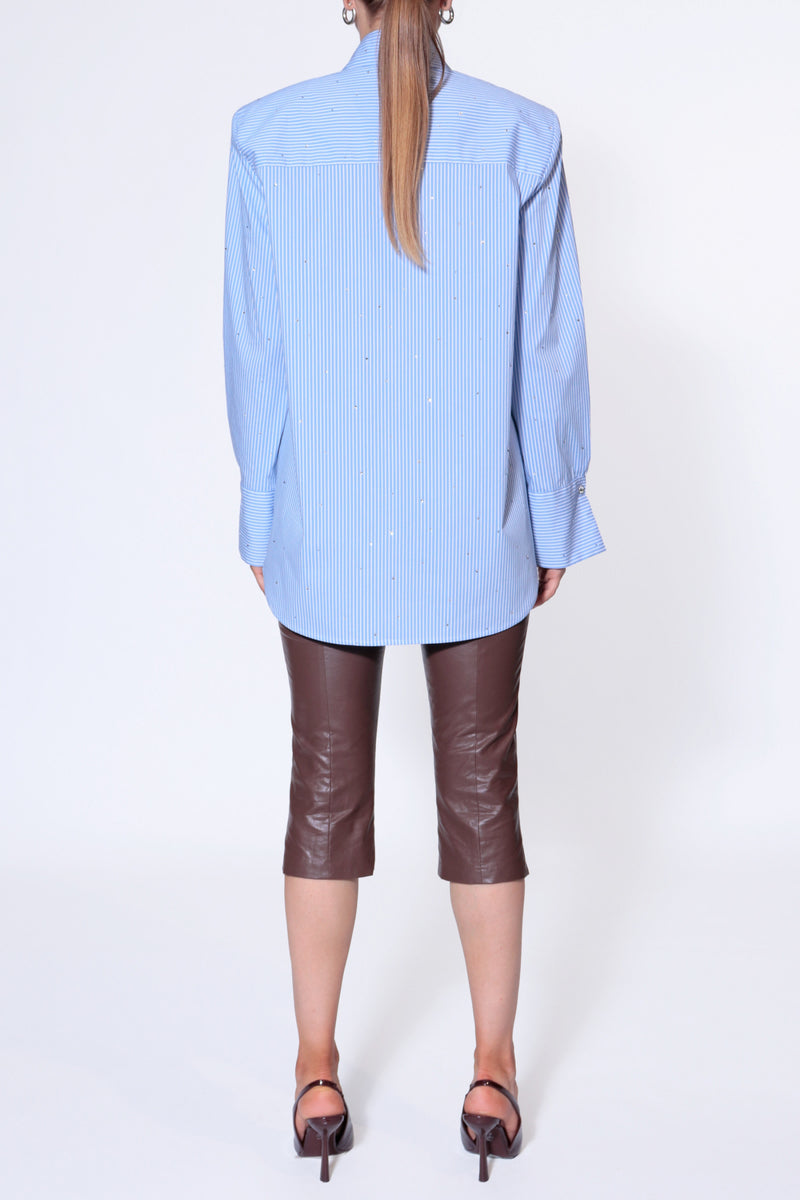 Light blue IRMA blouse by AGGI by HALEWSKI, stylish shirt with a relaxed fit and soft fabric, displayed on a hanger.