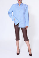 Light blue IRMA blouse by AGGI by HALEWSKI with long sleeves and a relaxed fit, displayed on a hanger.
