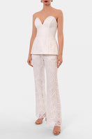 Off-white embroidered LAMIA corset top by AGGI by HALEWSKI with intricate embroidery and fitted design.