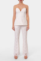 Off-white embroidered corset top by AGGI by HALEWSKI, featuring intricate embroidery and a fitted, stylish design.