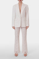 Off-white embroidered pants from AGGI by HALEWSKI featuring detailed embroidery and a relaxed fit.