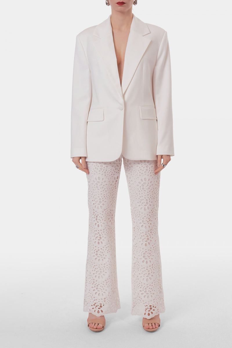 Off-white embroidered pants from AGGI by HALEWSKI featuring detailed embroidery and a relaxed fit.