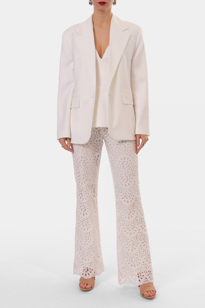Off-white embroidered pants from AGGI by Halewski, featuring detailed embroidery and a relaxed fit.