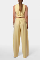 AGGI by HALEWSKI OMENA Butter Yellow Pants, stylish casual pants in vibrant yellow, shown on a model with relaxed fit and side pockets.