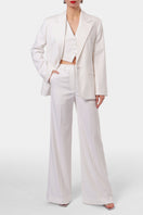 Off-white AGGI by Halewski Franzi pants with tailored fit and sleek design, showcased on a clothing rack.