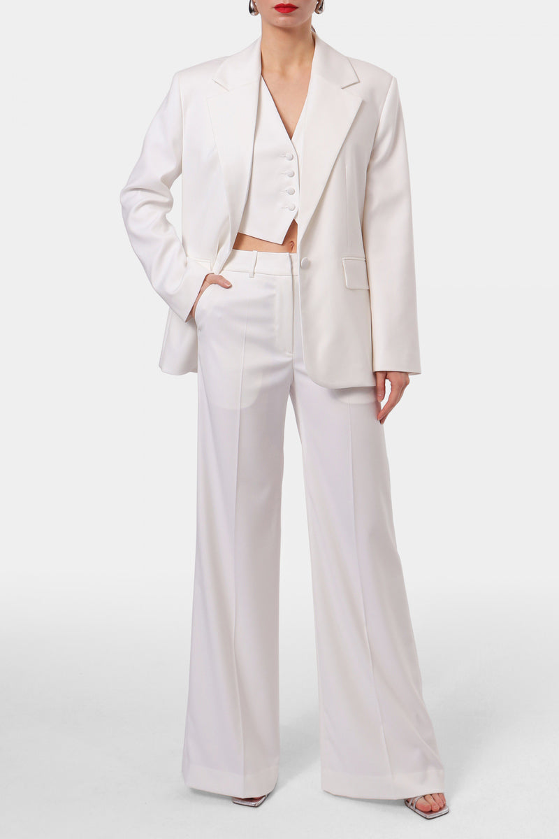 Off-white AGGI by Halewski Franzi pants with tailored fit and sleek design, showcased on a clothing rack.