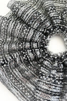 Aethera Branka X-Large Sequin Scrunchie in vibrant silver with shiny sequins, styled around a woman's hair.