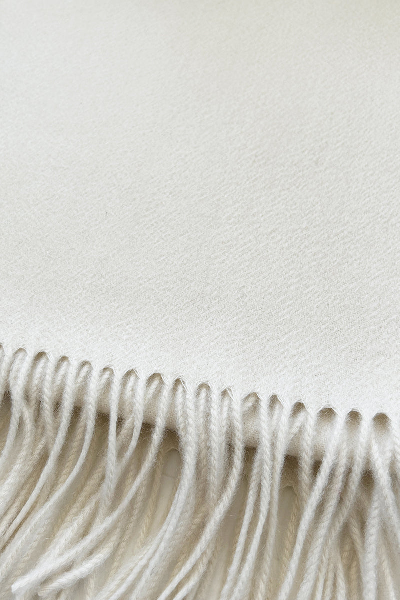 Aethera Helena cashmere shawl in blanc, showcasing soft, luxurious fabric draped elegantly for cozy, stylish wear.