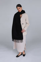 Aethera Helena cashmere shawl in nero, draped elegantly showing soft black cashmere fabric and stylish design.
