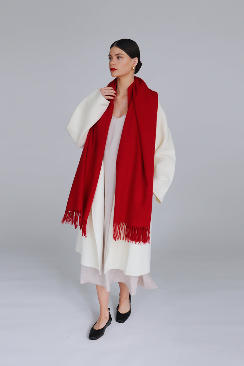 Aethera Serene lambswool shawl in crimson draped elegantly, showcasing soft texture and vibrant color for stylish warmth.