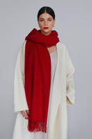 Crimson Aethera Serene Lambswool Shawl draped elegantly, showcasing soft, luxurious wool fabric with fringed edges.