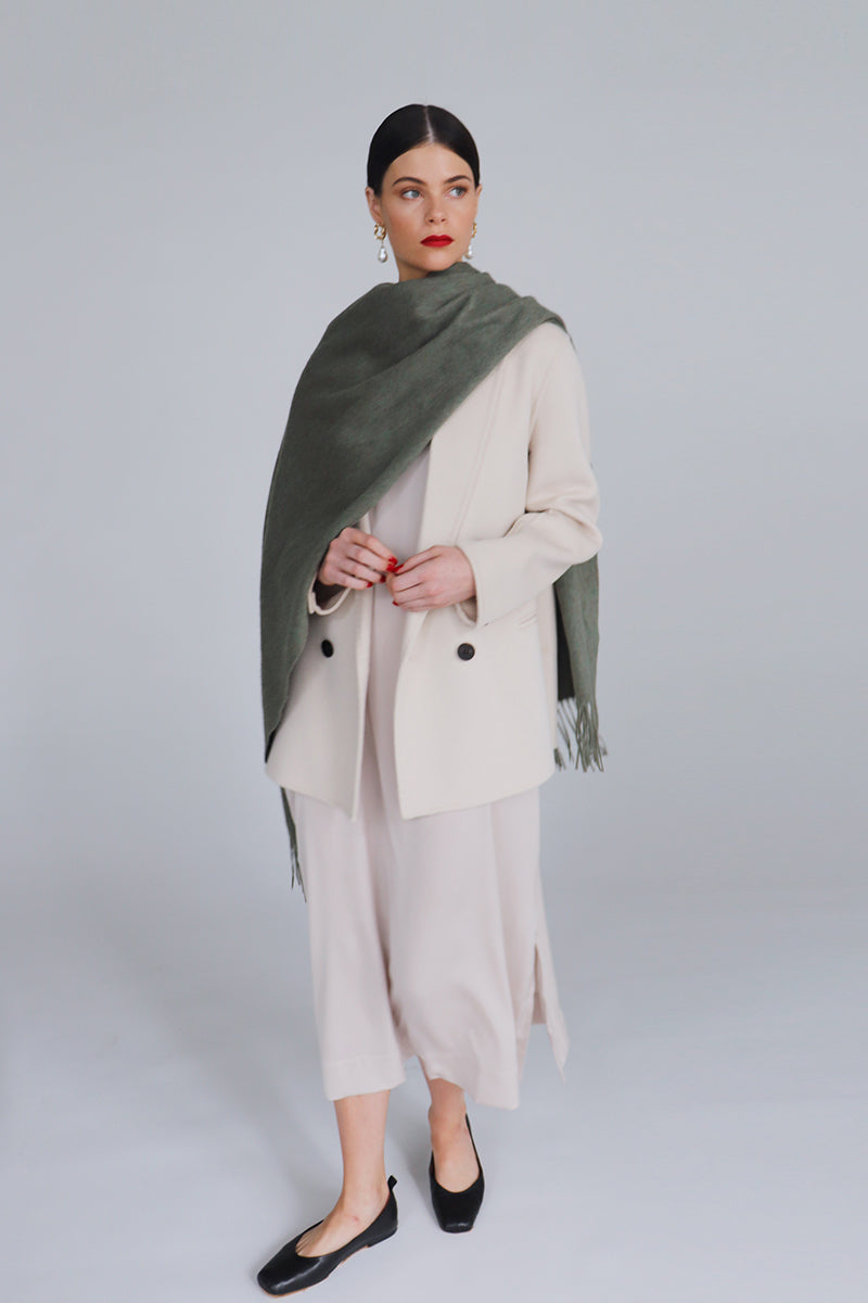 Aethera Serene Lambswool Shawl in soft celadon green, draped to showcase its cozy, lightweight wool texture.