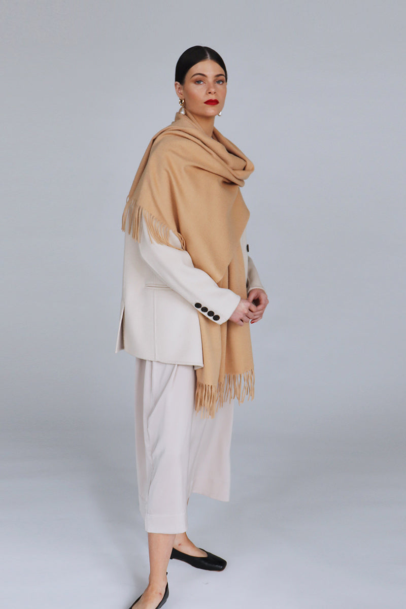 Aethera Helena cashmere shawl in warm camel color, draped elegantly to showcase soft, luxurious cashmere fabric and stylish design.
