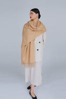 Aethera Helena cashmere shawl in camel draped elegantly, showcasing its soft texture and stylish design.