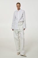 White embroidered shirt by DELEGAN, featuring detailed embroidery on soft fabric, perfect for casual or semi-formal wear.