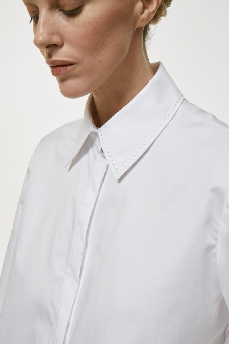White embroidered shirt by Delegan, featuring intricate embroidery details and classic shirt design.
