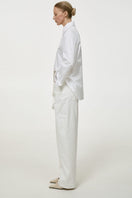 Milk-colored relaxed fit jeans by DELEGAN, showing a casual denim style with a comfortable, loose fit and classic jean details.