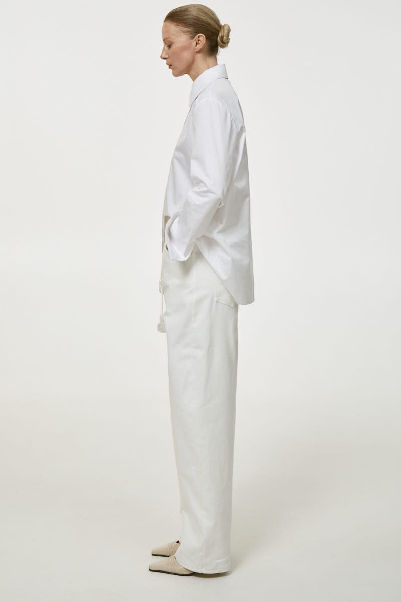 Milk-colored relaxed fit jeans by DELEGAN, showing a casual denim style with a comfortable, loose fit and classic jean details.