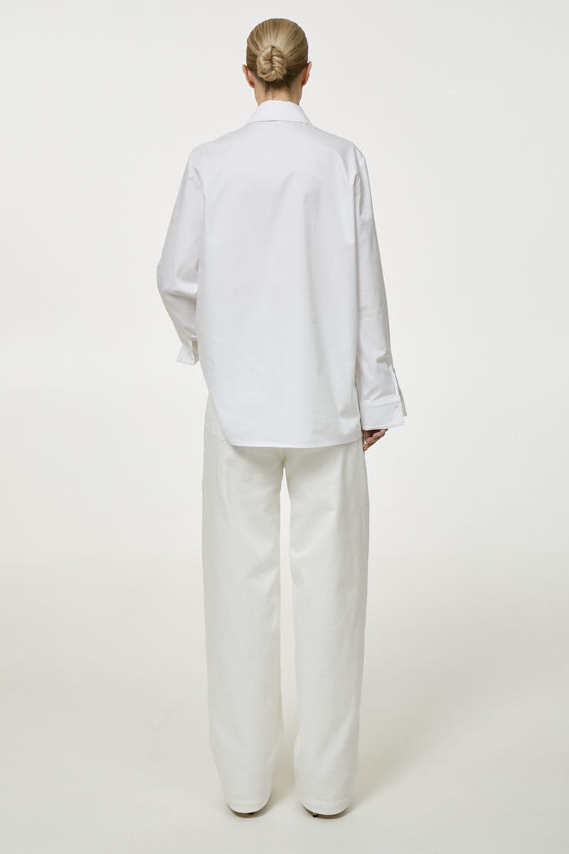 White embroidered shirt by DELEGAN, showcasing intricate embroidery details on a classic shirt style.