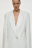 White satin lapel jacket by DELEGAN, stylish men's jacket with smooth satin fabric and tailored fit, shown on a hanger.