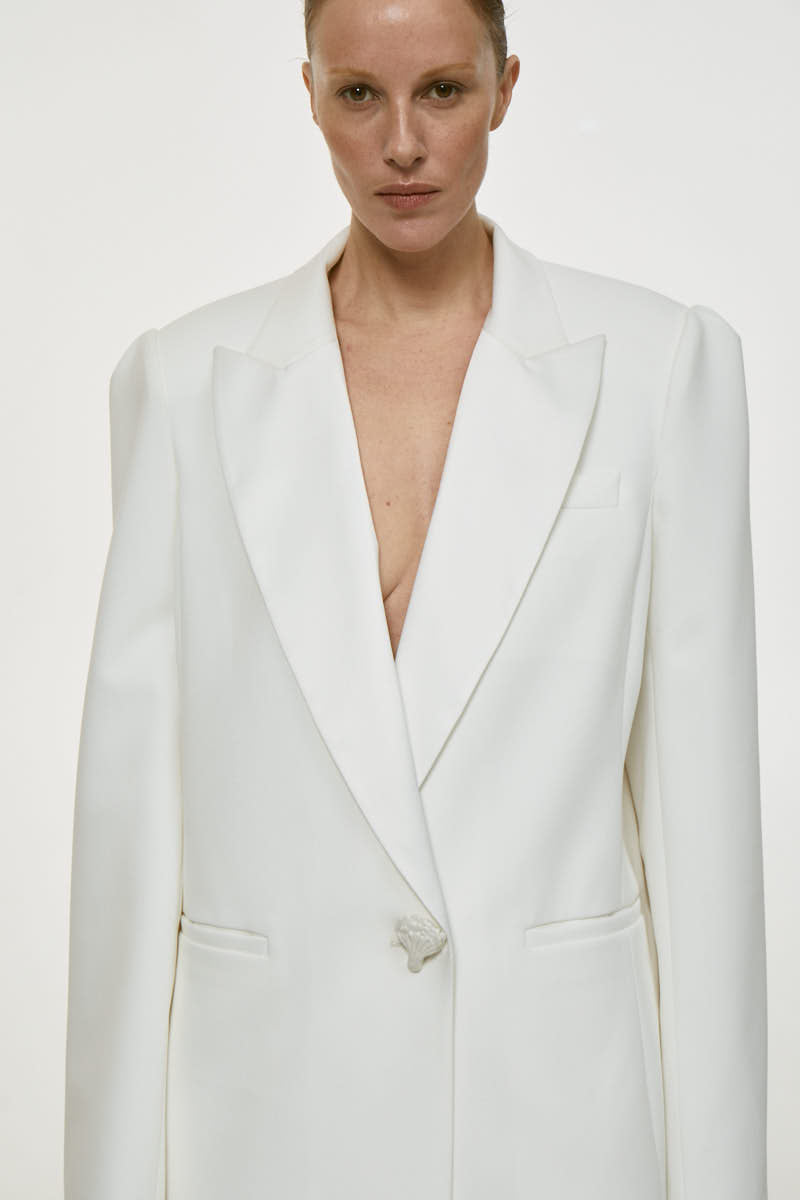 White satin lapel jacket by DELEGAN, stylish men's jacket with smooth satin fabric and tailored fit, shown on a hanger.