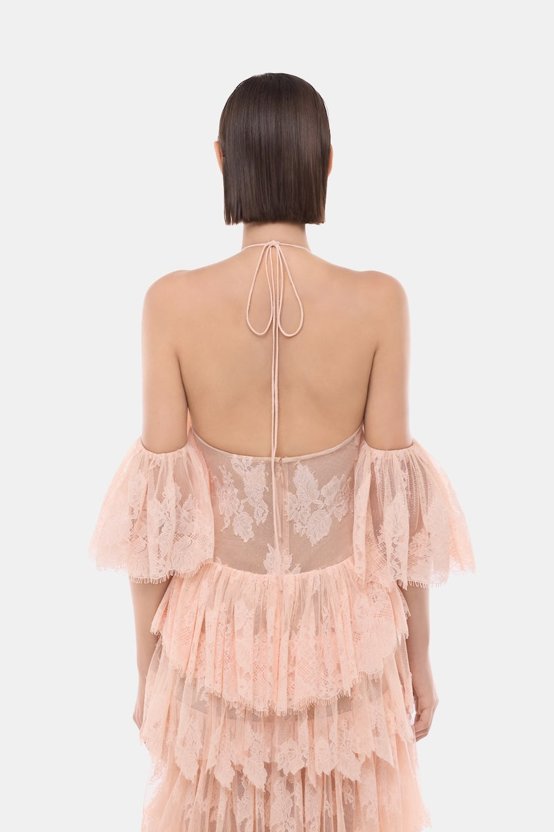 Peach ruffled halter gown by Montsand featuring a flowing silhouette and elegant ruffle details.
