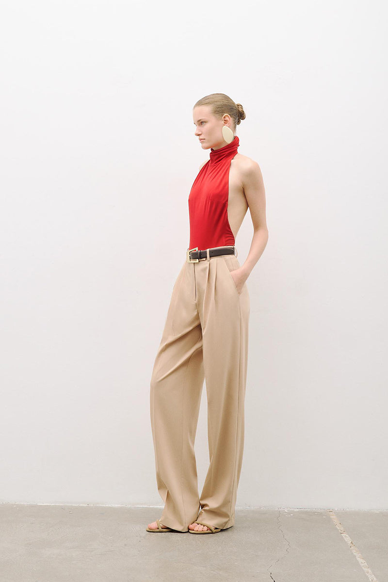 Beige double-pleated wide-leg pants by AWAVE, shown on a model, featuring a relaxed fit and flowing fabric.
