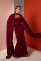 Elegant burgundy twist gown by Joanna Andraos featuring a flowing design and sophisticated silhouette.
