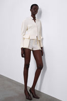White ELEN double layer shorts by SÉLONE featuring a layered design and relaxed fit, shown on a model.